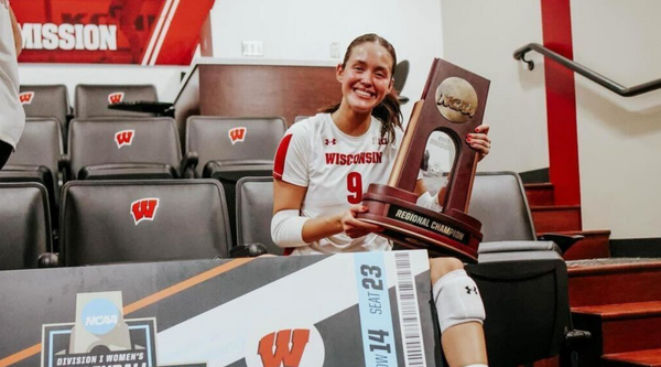 Caroline 'CC' Crawford, a senior volleyball player for the University of Wisconsin, smiles as she holds the NCAA Regional Champion trophy.