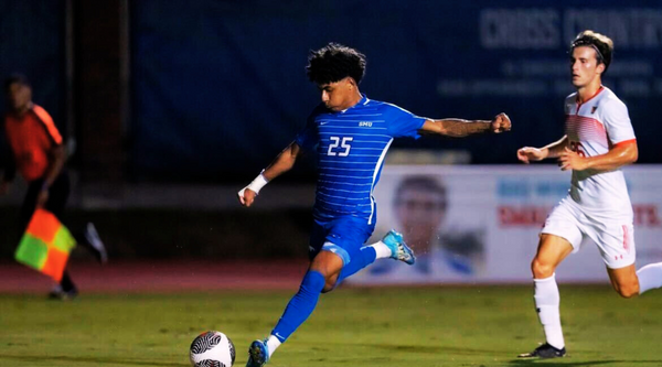 Jaylinn Mitchell, sophomore midfielder for SMU Soccer, kicking a soccer ball during a nighttime game, with 'Jaylinn Mitchell - Sophomore Midfielder for SMU Soccer' text on the image.