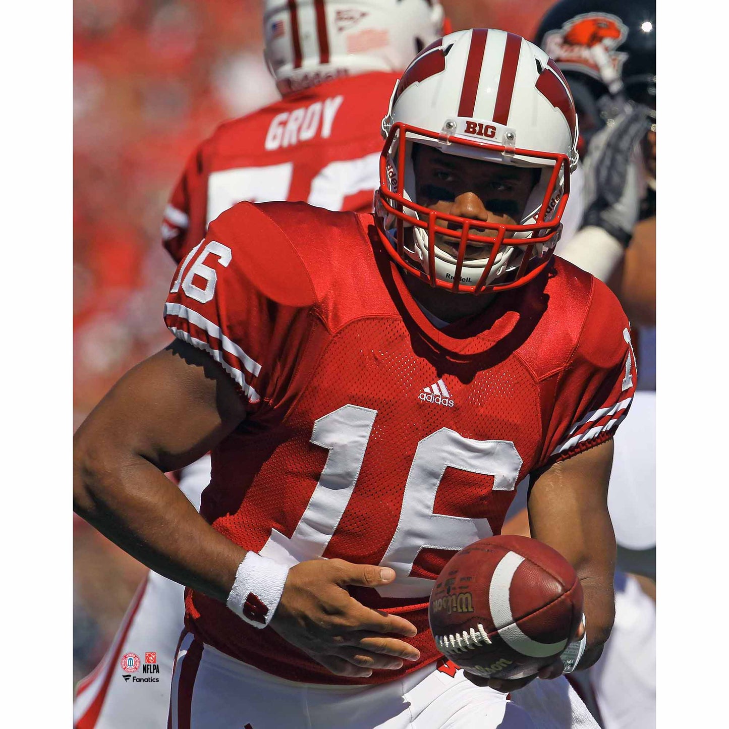 Russell Wilson Wisconsin Badgers Unsigned Red Jersey Handing Off Ball Photograph